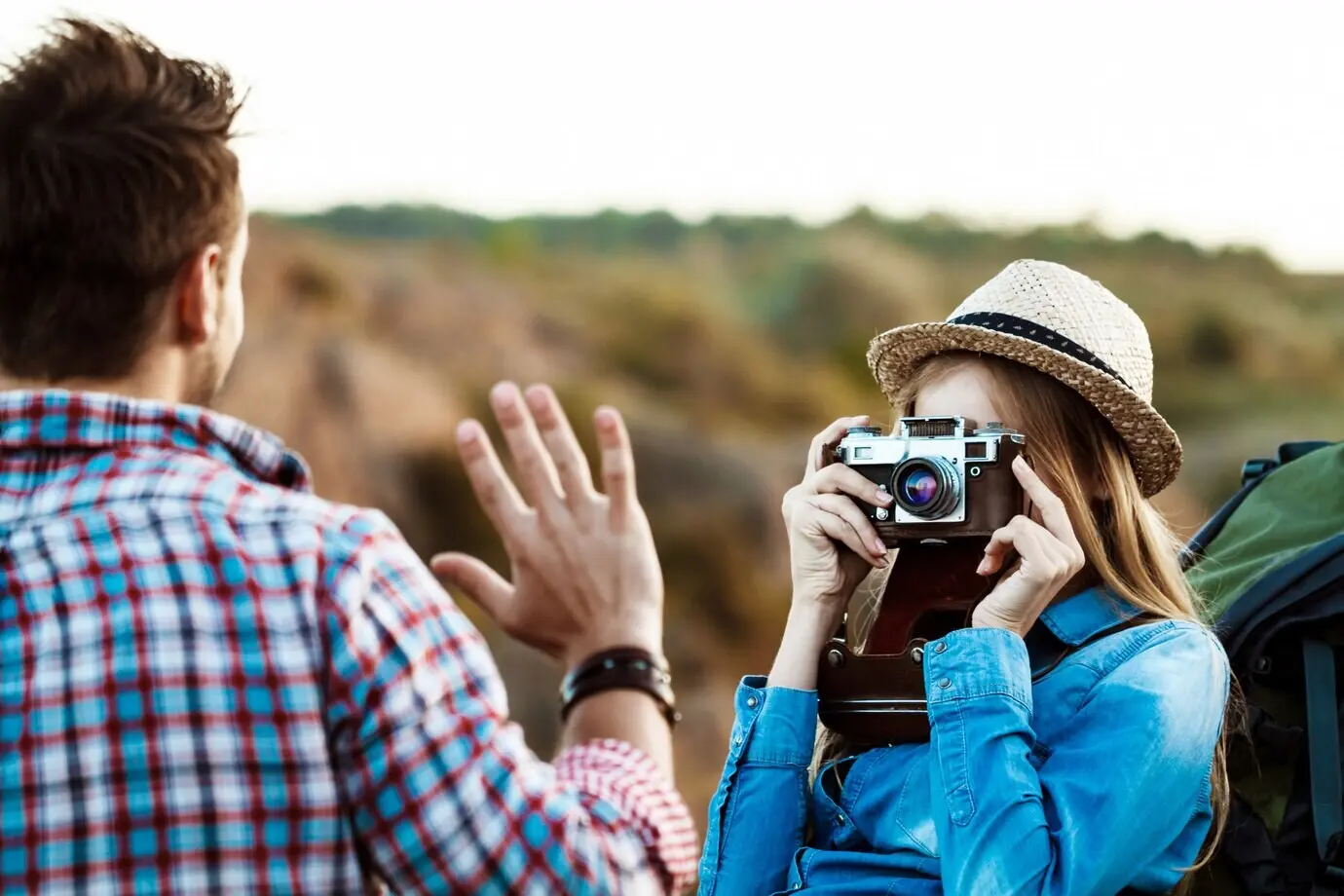 Schöne blonde Fotografin macht ein Foto von ihrem Freund.